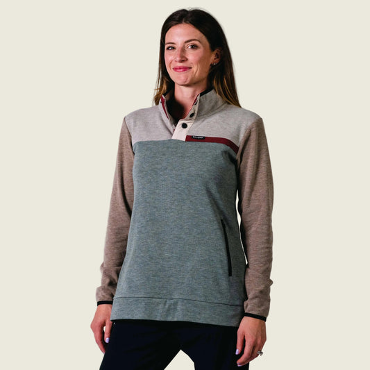 Woman wearing an aqua and brown pullover against a white background