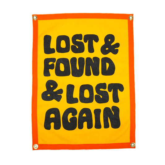 Yellow sign with black text 'LOST & FOUND & LOST AGAIN' on an orange border.
