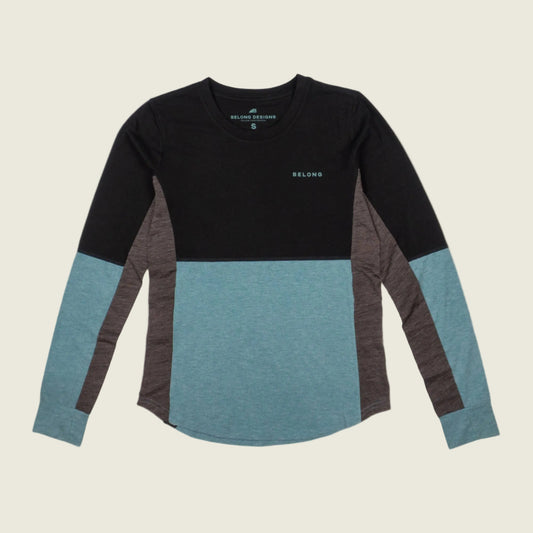 Color-blocked long-sleeve shirt with black, blue, and gray sleeves on a beige background